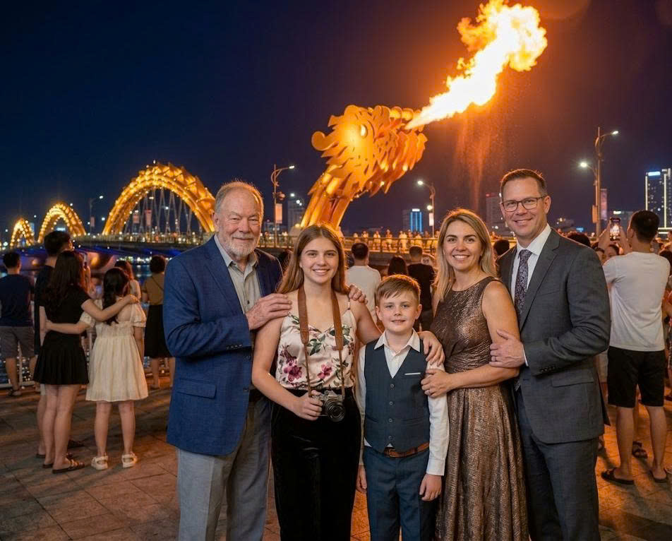 A family enjoying the vibrant night atmosphere while watching the Dragon Bridge breathe fire in Da Nang, Vietnam.
