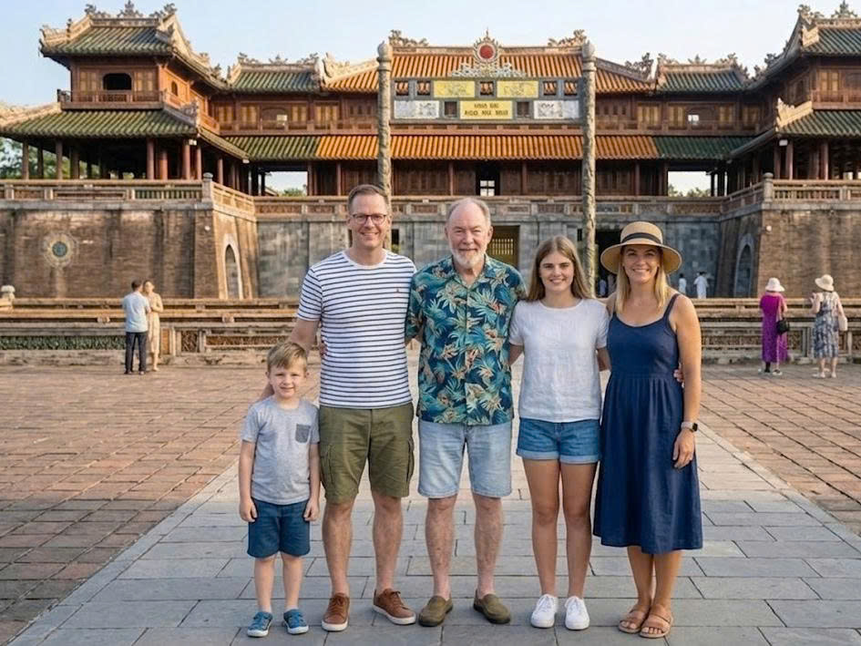 A family posing in front of the magnificent ancient gates of the Hue Imperial Citadel, Vietnam.